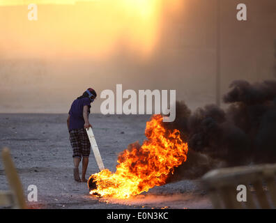 Ma'Ameer, Bahreïn. 16 mai, 2014. Manifestant masqué bahreïnies à Ma'ameer brûlent des pneus lors d'une manifestation pour protester contre l'assassinat de l'activiste Ali Faisal Aekrawi (19 ans), qui a été tué le matin du vendredi 16 mai à l'hôpital. (Photo par Ayman Yaqoob/Pacific Press) Banque D'Images