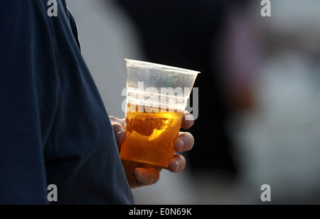 Homme avec plastique verre de bière blonde Banque D'Images