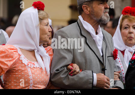 Deux femmes en costumes chulapa reliant les bras d'un homme habillé en chulapo, Fiesta de San Isidro, Madrid Banque D'Images