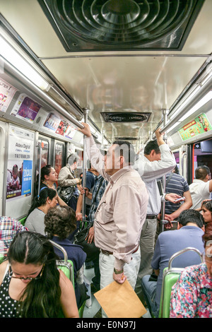 L'intérieur de la ville de Mexico métro bondé avec divers voiture passagers habillés pour le printemps journée de détente entre les arrêts Banque D'Images