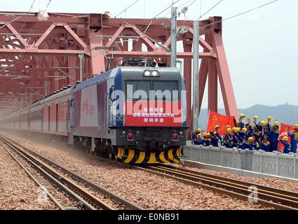 (140517) -- ZHENGZHOU, 17 mai 2014 (Xinhua) -- en tant que travailleurs cheer le premier train de voyageurs traverse un nouveau pont sur le Fleuve Jaune à Zhengzhou, capitale de la province du Henan en Chine centrale, le 16 mai 2014. Les quatre premières voies pont ferroviaire sur le fleuve Jaune, le deuxième plus long de Chine, a été mis en service le vendredi, en remplacement d'une construction à deux voies qui avait été en service depuis 1960. Deux lignes du 2 200 mètres de long pont de chemin de fer Beijing-Guangzhou sont pour alors que les deux autres sont pour les trains interurbains entre Zhengzhou et Jiaozuo, une ville dans le Henan. (Xinhua/Wang Song) (WF) Banque D'Images