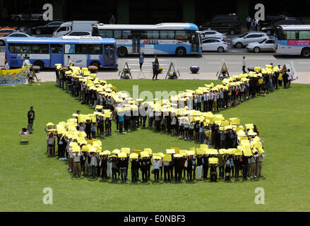 Séoul, Corée du Sud. 16 mai 2014. Les gens détiennent des panneaux jaunes et faire une forme d'un ruban jaune, tous ensemble dans le deuil pour les victimes de l'Sewol ferry et souhaiter le retour des passagers manquant lors d'une flash mob, Séoul, Corée du Sud, le vendredi 16 mai 2014. Les participants ont demandé d'enquêter et de révéler les faits de la tragédie de ferry qui a causé plus de 300 morts ou disparus après avoir été enfoncés dans les eaux au large de la sud-ouest de l'île de Jindo le 16 avril 2014. Credit : Jaewon Lee/Alamy Live News Banque D'Images