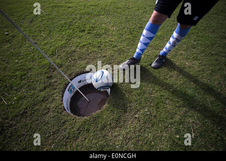 Buenos Aires, Argentine. 16 mai, 2014. Un FootGolf player kicks une balle dans un trou lors d'un tournoi de golf dans un domaine de Tigre, 35 kilomètres de Buenos Aires, capitale de l'Argentine, le 16 mai 2014. FootGolf est un sport généralement joué sur un parcours de golf, où les joueurs de football d'un coup de pied dans un trou avec le moins de coups possible. © Martin Zabala/Xinhua/Alamy Live News Banque D'Images