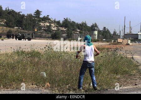 Ramallah, Palestine. 16 mai, 2014. Ramallah, Cisjordanie, territoire palestinien le 16 mai 2014 : manifestant palestinien utilisé des lance-pierres au cours d'affrontements à l'extérieur de la prison d'Ofer israélienne-run, près de la ville de Ramallah, en Cisjordanie, le 16 mai 2014. un jour après que deux Palestiniens ont été tués par les forces israéliennes au cours d'affrontements à l'extérieur de la prison d'Ofer run-israélienne après une protestation à l'occasion de ''Nakba'' ou ''catastrophe'' de l'état juif de sa création. © Museitef NurPhoto Abdalkarim //ZUMAPRESS.com/Alamy Live News Banque D'Images