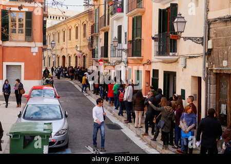 Les gens attendent à l'extérieur de l'entreprise qui offre 120 lieux temporaires dans l'île de Majorque, Espagne Banque D'Images