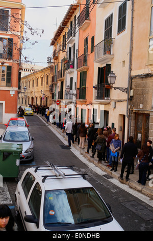Les gens attendent à l'extérieur de l'entreprise qui offre 120 lieux temporaires dans l'île de Majorque, Espagne Banque D'Images