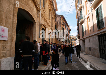 Les gens attendent à l'extérieur de l'entreprise qui offre 120 lieux temporaires dans l'île de Majorque, Espagne Banque D'Images