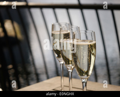 Trois verres de champagne dans une rangée sur une table en bois Banque D'Images