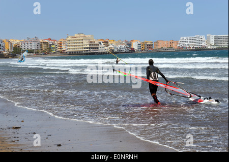 Wind surfer sur la plage d'El Medano, Tenerife avec voile et conseil, ville de El Medano en arrière-plan Banque D'Images