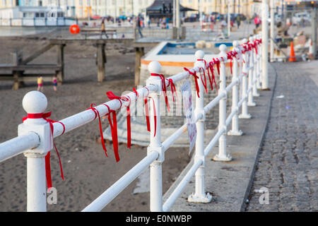 Aberystwyth, Pays de Galles, Royaume-Uni. 17 mai, 2014. Le garde-corps le long de la promenade à Aberystwyth, Pays de Galles, ont été ornées de rubans rouges pour attirer l'attention sur la campagne de "ramener nos filles'. Ce sont les filles de l'école de 230 qui ont été enlevés de l'Chibok École secondaire par les terroristes de Boko Haram au Nigeria. Credit : atgof.co/Alamy Live News Banque D'Images