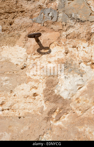 Rusty hook détail sur mur de pierres sèches jaune ocre. Majorque, Baléares, Espagne. Banque D'Images