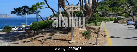 Panorama, centré signe Bar S'Illot' pointant vers la gauche et courbes chemin qui monte la colline sur la péninsule d''Alcudia Majorque, Espagne. Banque D'Images