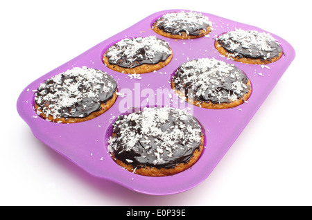 Libre de carotte frais cuit muffins au chocolat et noix de coco desséchée en moule en silicone. Isolé sur fond blanc Banque D'Images