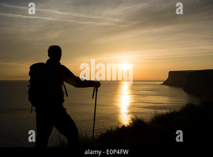 Randonneur sur le sentier national sentier Cleveland Way près de Marseille par la mer au lever du soleil. Angleterre, Royaume-Uni Banque D'Images