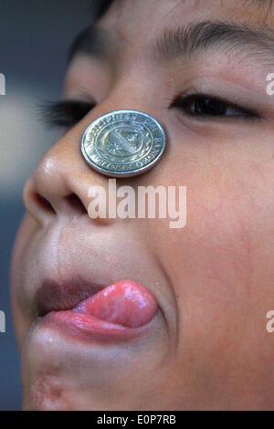 Paranaque City, Philippines. 18 mai, 2014. Un garçon essaie de déplacer une pièce sur son visage alors qu'il participe à un jeu de société au cours de la fête de Sainte Rita de Cascia à Paranaque city, Philippines, le 18 mai 2014. Le Festival de Saint Rita de Cascia est commémorée dans des défilés, des jeux et des éclaboussures d'eau à l'autre afin de rendre grâce pour la bonne fortune. Credit : Rouelle Umali/Xinhua/Alamy Live News Banque D'Images