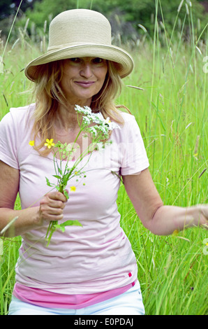 Woman with hat Picking Flowers Banque D'Images