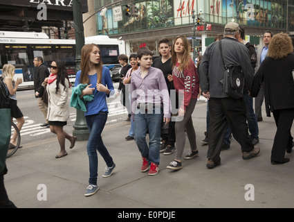 Les jeunes touristes de vérifier certains des sites touristiques le long de la 42e Rue à New York. Banque D'Images