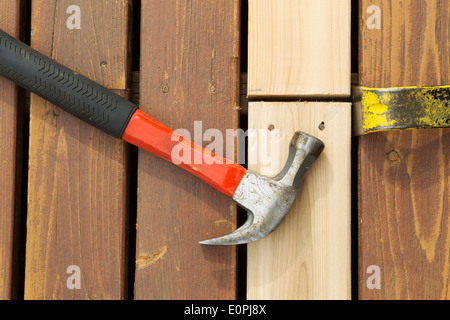 Photo horizontale de marteau et pied de biche en alignant les nouveaux conseils pour l'installation sur bois de cèdre Banque D'Images