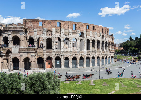 Le Colisée, Rome, ruines spectaculaires de l'époque de la Rome Impériale, avec chariots pour les touristes sur une journée ensoleillée Banque D'Images