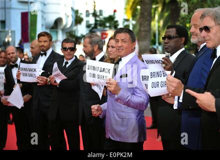 (140518) -- CANNES, Mai 18, 2014 (Xinhua) -- En fonte de 'l'usure 3', holding up banners lire 'Ramener nos filles", dans le cadre d'une campagne appelant à la libération des écolières nigérianes enlevées étant détenu par le groupe extrémiste islamique nigérian Boko Haram, lorsqu'ils arrivent sur le tapis rouge pour la projection de 'la' Homesman à la 67ème Festival du Film de Cannes, dans le sud de la France, le 18 mai 2014. (Xinhua/Chen Xiaowei) Banque D'Images