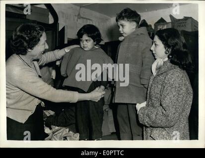 01 janvier 1957 - Réfugiés britanniques d'Egypte.. Tous les jours sur sept cents réfugiés britannique de l'Egypte - la visite de la société Anglo - Aide égyptien, Regent's Park - pour obtenir de l'aide - travail, etc.. La plupart d'entre eux ont tout perdu lorsqu'ils ont été forcés de quitter l'Égypte. Photo : Keystone montre- Mme Dorothy Goodwin (à gauche) et ex-réfugiés - et maintenant l'un des aidants - aider Mme Biancardi monter ses deux enfants Kathleen (3) et Liciano (5) avec les vêtements. Leur père était un directeur commercial à Alexandrie. Banque D'Images