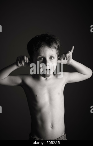 Boy (4-5 ans) s'en tenir sa langue out Banque D'Images