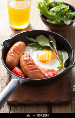 Œuf frit tomates saucisses dans le moule pour le petit déjeuner Banque D'Images