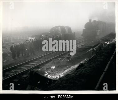 01 janvier, 1958 - 10 tués et 87 blessés dans deux trains entrent en collision dans un épais brouillard à Dagenham : Deux personnes ont été tuées et quatre-vingt-sept blessés hier soir dans un autre train crash lorsqu'un train de passagers entassés à l'arrière d'un contre un sur la ligne de Southend occupé comme le dernier des trains aux heures de pointe à partir de la rue Fenchurch a eu lieu à la maison des travailleurs. Photo montre un Londres-bound train passe la scène de l'accident après l'épave avait été effacée et le service a été repris pour le trafic aux heures de pointe, ce matin. Banque D'Images