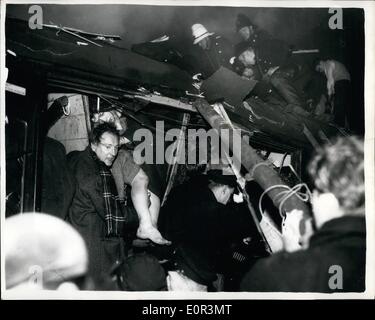01 janvier 1958 - Dix personnes ont été tuées et quatre-vingt-sept blessés hier soir dans un autre accident ferroviaire dans un épais brouillard lorsque des trains s'est écrasé dans l'arrière d'un train immobilisé à Ragenham. Il s'est passé sur la ligne de Southend occupé comme le dernier des trains aux heures de pointe d'Fenchuruh ont pris la rue ville accueil des travailleurs. Photo montre le sosne d'horreur quelques instants après les deux paniers de l'heure de train s'est écrasé dans l'épais brouillard. Les travailleurs sont Resoue vu essayer de sortir certains des blessés de l'entraîneur en rack, tandis que fireman hack leur chemin à travers le toit en bois. Banque D'Images