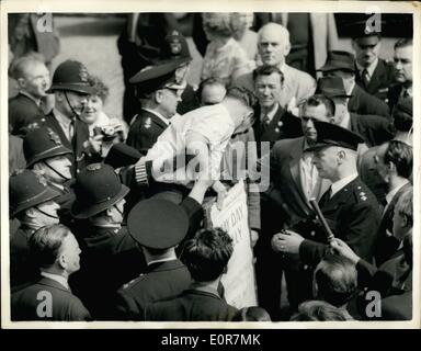 Mai 05, 1958 - La Police Briser Réunion à St Pancras Town Hall. Aujourd'hui, les étudiants ont manifesté devant l'hôtel de ville de St.Pancras Union Jacks, après le conseil dominé par les socialistes a décidé de hisser le drapeau rouge sur l'immeuble. La police a dispersé une réunion et procédé à des arrestations. Photo : Keystone montre- Clir. John Lawrence, chef de la St.Pancras Conseil, est tiré vers le bas de son stand et arrêté lorsqu'il s'agit d'une réunion à l'extérieur de St.Pancras town hall. Banque D'Images