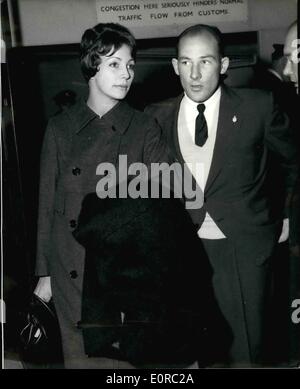 01 janv., 1959 - Stirling Moss et son épouse arrivent à la maison. La photo montre la course du moteur Stirling Moss et son épouse à leur arrivée à l'aéroport de Londres la nuit dernière d'une maison de vacances à Bangkok après qu'il avait gagné le Grand Prix en Australie et en Nouvelle-Zélande. Stirling a dit qu'il a été "taggerd" par la mort de son ami et pilote de course Mike Hawthorn. Banque D'Images