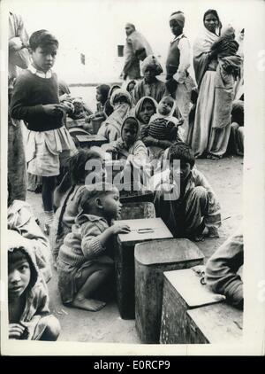 16 janvier 1959 - La pénurie alimentaire dans Delhi, File d'attente pour le grain ; Continu pénurie alimentaire dans Delhi constitue une menace pour l'ordre public dans la capitale indienne. De longues files d'attente des femmes et des enfants, qui vivent sur un repas par jour à la boutique des marchands de grains qui ont augmenté leurs prix de 25  % dans les vingt jours. Les gens réclament l'ouverture du gouvernement 40 ''Juste Prix'' des magasins. Photo montre des femmes et des enfants attendent patiemment pour le grain d'ouvrir des magasins à Delhi avec leurs grandes cellules à grains. La pénurie alimentaire est si aiguë que les concessionnaires vont leur permettre seulement un Rupee est en valeur un jour. Banque D'Images