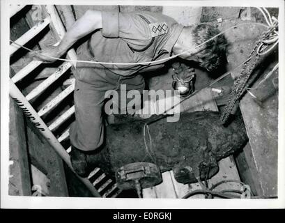 Juillet 07, 1959 - PUTNEY'S BOMB EST-dispossl bombe éclatée hommes ont travaillé toute la nuit pour un hammam à sam même de l'explosif avant la réparation des accidents du travail du Conseil Bendemeer-road, Putney hier. La bombe a été piégées et «très dangereux'' et a été abandonnée dans un raid aérien de 1940. Familles de la route avaient été évacués et lorsque la bombe a explosé à l'avait été evacated, et lorsque la bombe a explosé à bas aujourd'hui, les fenêtres ont été soufflées dans shatttered troués et toits de maisons PHOTO MONTRE :- la nuit dernière, l'image d'un officier qui descend jusqu'à la bombe. Banque D'Images