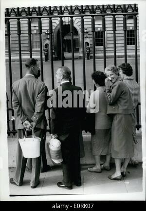 10 octobre 1959 - Palais sentinelles aller derrière le garde-corps. : Pour la première fois, les sentinelles à Buckingham Palace ont été ce matin, et en bas derrière les grilles du palais de Buckingham, au lieu d'en face d'eux. Le War Office a ordonné le changement parce que le grand nombre de touristes commence à harceler les hommes. Photo montre tôt le matin vu les visiteurs à la recherche à travers les garde-fous aux les sentinelles qui sont maintenant en arrière contre le mur du palais, après changement de ce matin. Banque D'Images