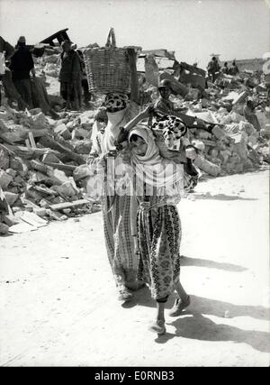 Mar. 04, 1960 - Après le tremblement de terre à Agadir. Ils transportent leurs biens terrestres. Photo montre deux jeunes femmes - avec tout ce qu'ils pouvaient sauver de leurs maisons - vu avec bâtiments détruits derrière - après le earthquakeat Agadir, Maroc., plus de 5 000 chemins permet pour morts. Banque D'Images