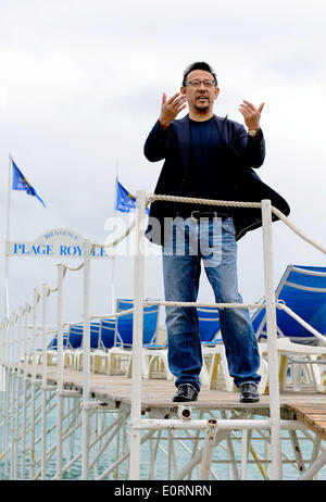 Cannes, France. 19 mai, 2014. Acteur et réalisateur chinois Jiang Wen se dresse sur la plage de Cannes, France, le 19 mai 2014. Jiang a présenté son nouveau film 'Autant en emporte le bullets' pour la promotion au cours de la 67e Festival de Cannes. Credit : Ye Pingfan/Xinhua/Alamy Live News Banque D'Images