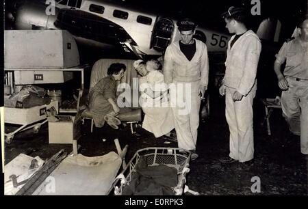 Mars 02, 1960 - séisme d'AGADIR. OPS : civières qui tapissent LE HANGAR DE LA BASE D'AGADIR AVEC LES MARINS QUI FRÉQUENTENT AUX BLESSÉS. Dans l'ARRIÈRE-PLAN UNE INFIRMIÈRE tenant dans ses bras un bébé qui pleure. Banque D'Images