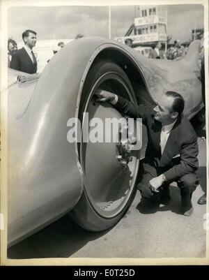 Juillet 07, 1960 - Campbell's ''Bluebird'' sur l'exposition. Donald Campbell's new Bluebird voiture, avec qui il va faire une tentative sur le Record de vitesse sur la Bonneville Salt Flats, Utah en septembre de cette année, a été présentée aujourd'hui au circuit de Goodwood motor aujourd'hui. La voiture, qui est alimenté par un moteur à turbine à gaz Proteus, devrait faire l'objet d'essais de vitesse faible préliminaire plus tard cette semaine. Le présent dossier s'établit à 394 m.p.h. créé par John Cobb. Photo montre M. Donald Campbell à la recherche à l'un des 4 pieds de géant. 4de Diamètre roues avant - à Goodwood aujourd'hui. Banque D'Images