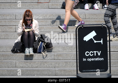 Londres, Angleterre, Royaume-Uni. Personnes à Trafalgar Square, assis sur les marches menant à la Galerie Nationale Banque D'Images