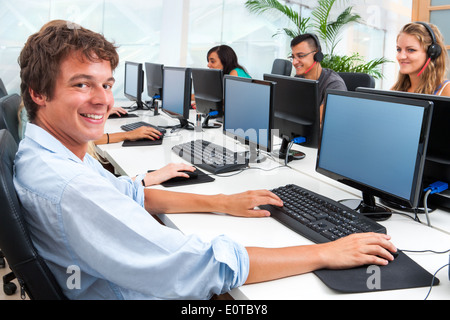 Jeune étudiant travaillant sur ordinateur dans bureau. Banque D'Images