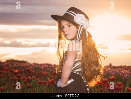 Jeune fille bénéficiant d'un champ de tulipes au printemps au coucher du soleil Banque D'Images