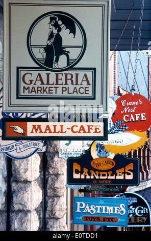 Les panneaux colorés attirent l'attention sur les nombreuses boutiques et restaurants le long de Spring Street, à Eureka Springs pittoresque, une charmante ville de l'Ozarks de l'Arkansas, USA. Banque D'Images