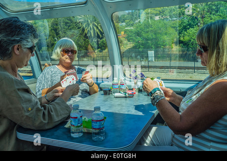 Trois femmes adultes âgées jouer aux cartes pour passer le temps sur un voyage en train. La voiture est une 1956 'historique Vista Dome Voiture-restaurant'. Banque D'Images