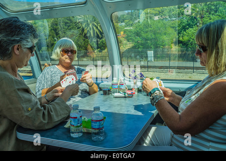 Trois femmes adultes âgées jouer aux cartes pour passer le temps sur un voyage en train. La voiture est une 1956 'historique Vista Dome Voiture-restaurant'. Banque D'Images