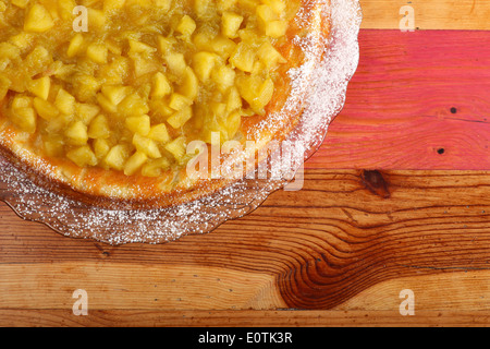 Gâteau sucré à la rhubarbe et les pommes sur la plaque de verre de sucre à glacer, table en bois peint rugueux Banque D'Images