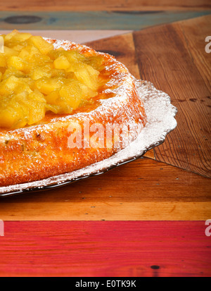 Gâteau sucré à la rhubarbe et les pommes sur la plaque de verre de sucre à glacer, table en bois peint rugueux Banque D'Images