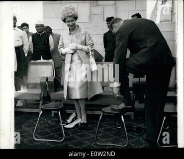 01 janvier 1961 - Reine visite les sanctuaires de Mahatma Gandhi. Duc met ses sandales.. Sa Majesté la Reine smilinjgly REGARDE LE DUC D'ÉDIMBOURG enlève ses chaussures pour porte une paire de sandales durant leur visite au sanctuaire du Mahatma Gandhi à la périphérie de New Delhi, le premier jour de leur visite.. Les sandales étaient speoially fourni pour le Couple Royal pour il est de coutume d'enlever ses chaussures pour visiter le sanctuaire. Banque D'Images