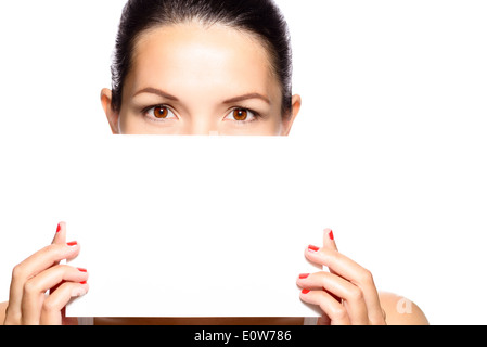 Belle femme avec une carte blanche avec copie espace en face de son visage que ses yeux d'un brun intense visible Banque D'Images