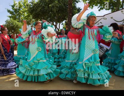 Les femmes portant des robes gitanes effectuer des danses andalouses traditionnelles à la Feria del Caballo, Jerez de la Frontera Banque D'Images