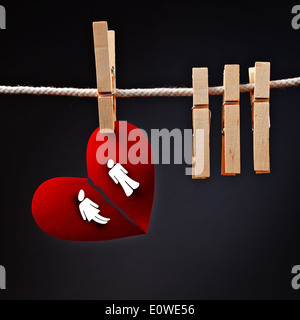 Couple hétérosexuel rupture conceptuelle, l'amour libre de papier coeur déchiré en deux, la pendaison sur corde avec une épingle à linge. Banque D'Images